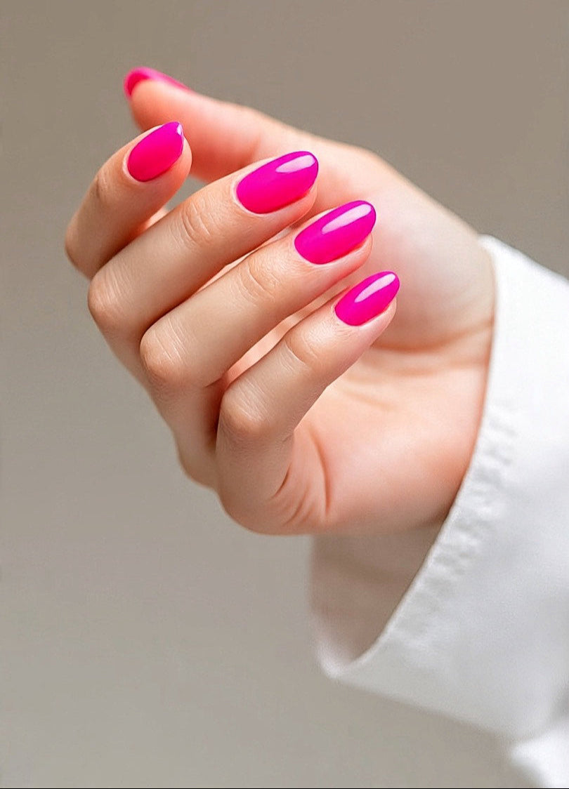 Hand with bright pink press on nails in a neutral background