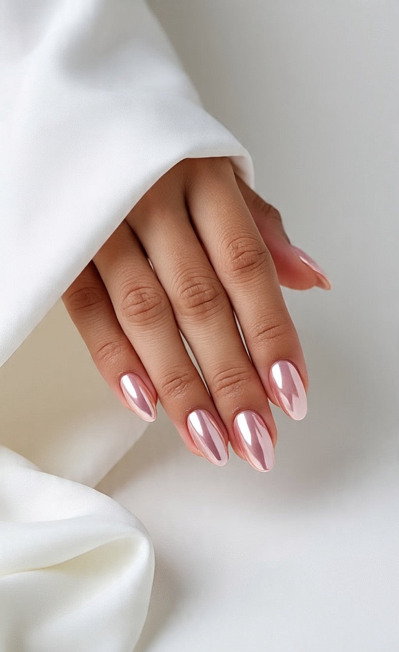 Close-up of a hand with pink chrome press on nails in a white background