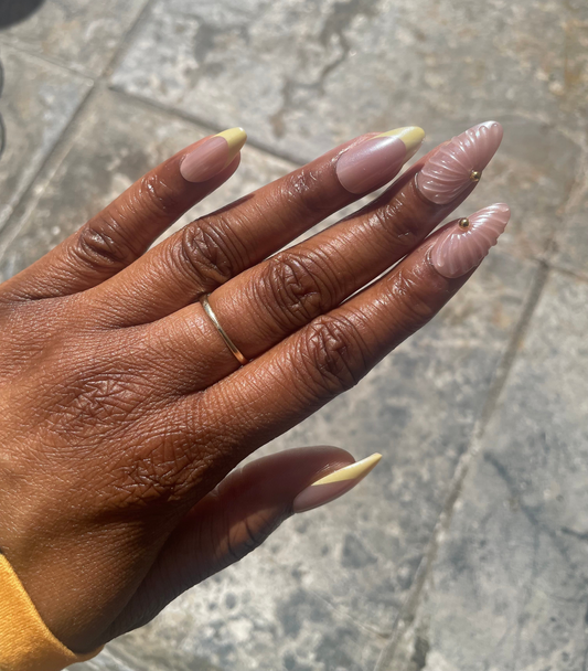 Close- up of Marbella yellow French shell accent press-on nails
