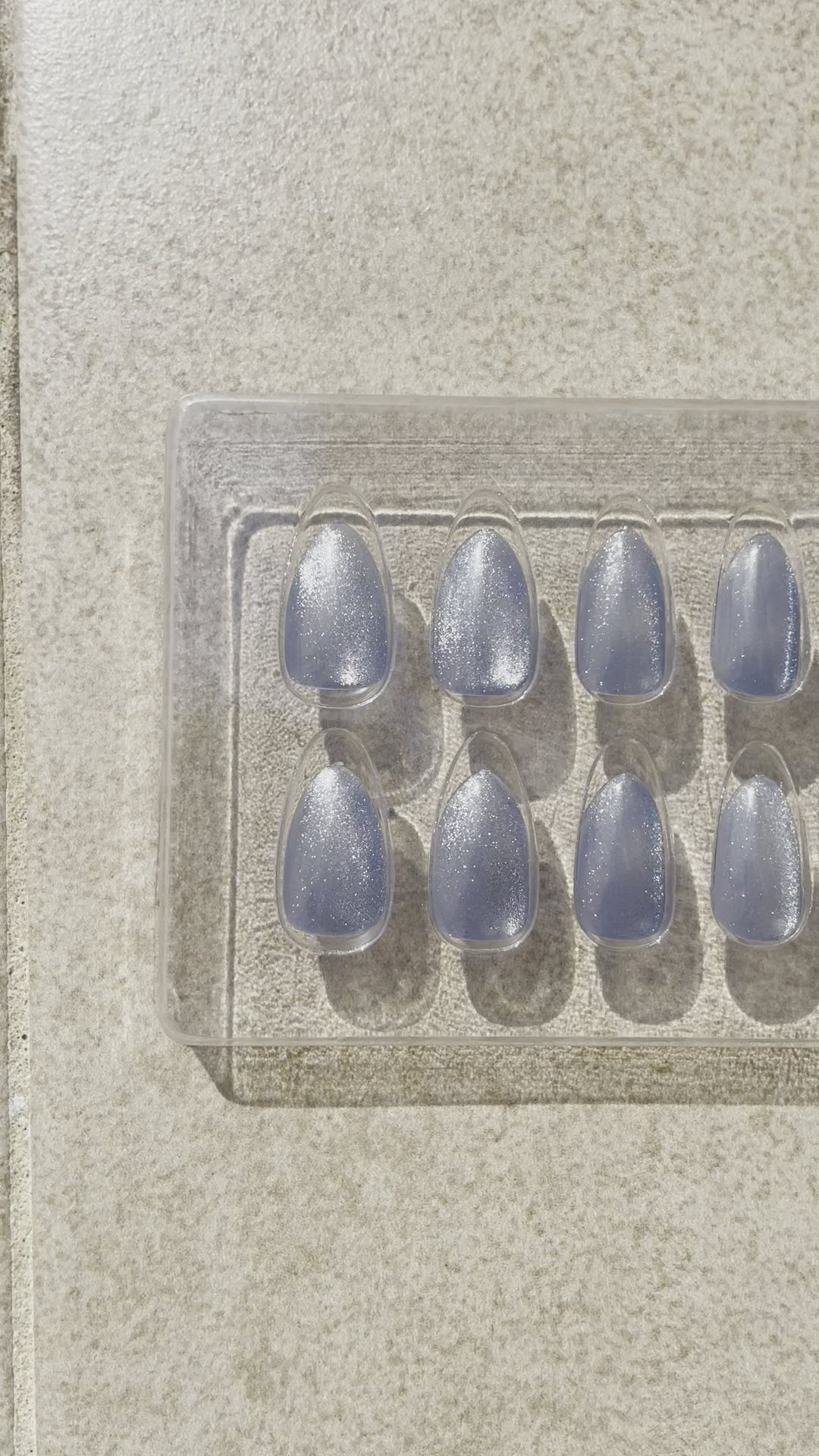 Blue Sea Almond made by Leewa Beauty Reusable almond-shaped press-on nails feature a stunning shade of blue and a breathtaking silver cat eye effect.