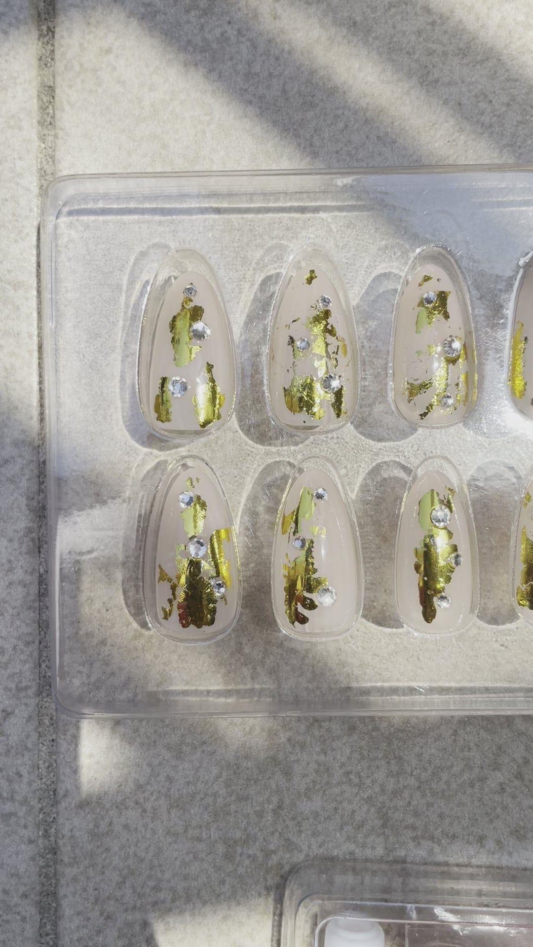 Medium Almond shaped Reusable press on nails with nude hue gold foil and rhinestones named Aureate Almond by Leewa Beauty Brand