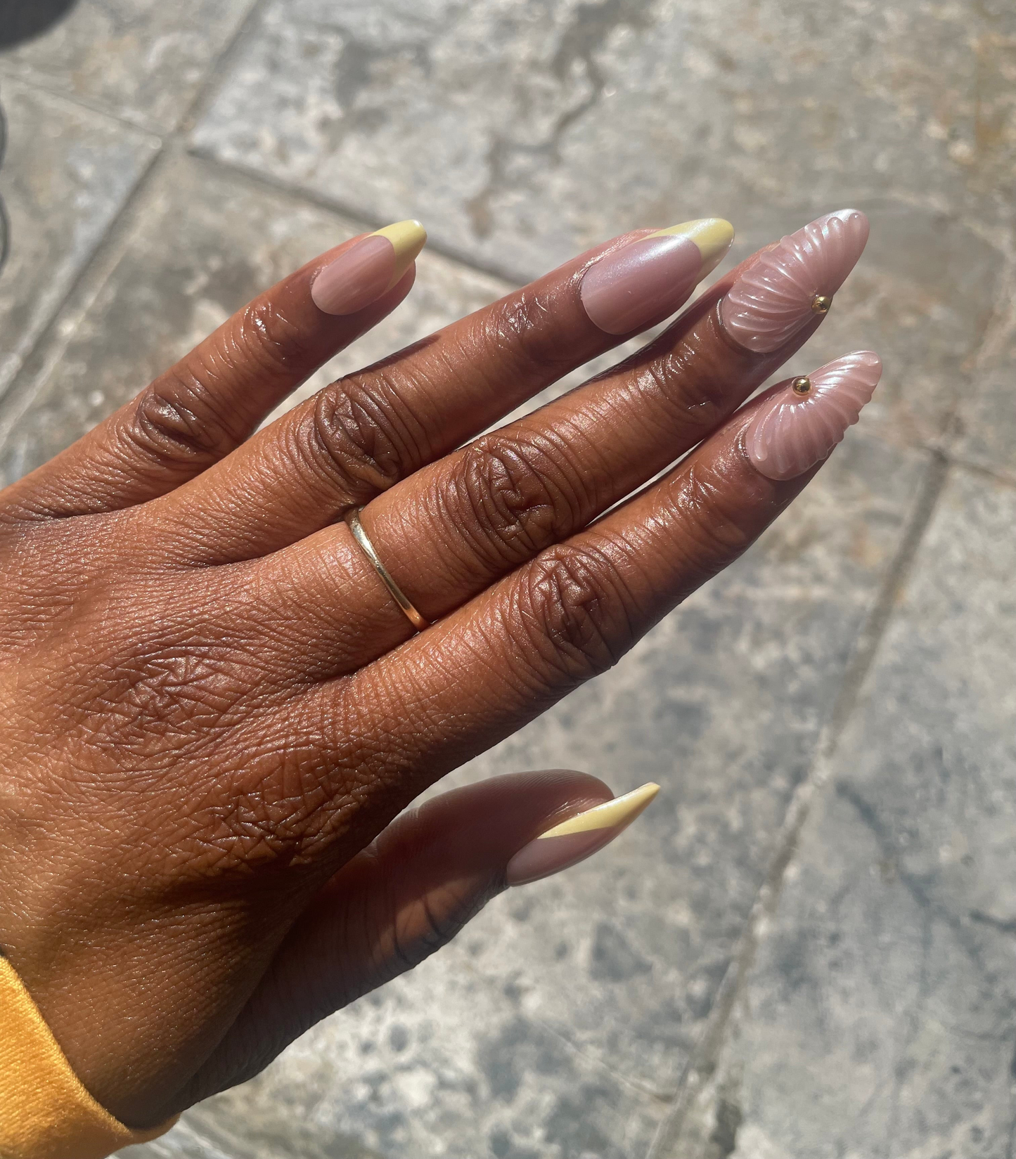 Close- up of Marbella yellow French shell accent press-on nails 